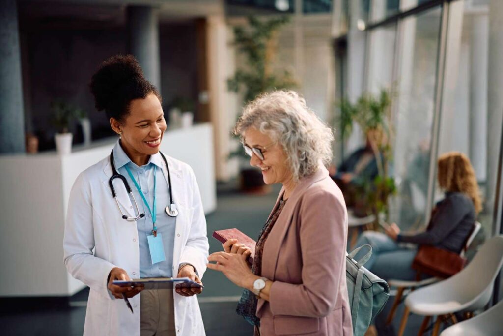 Médico conversando com paciente idosa em consultório